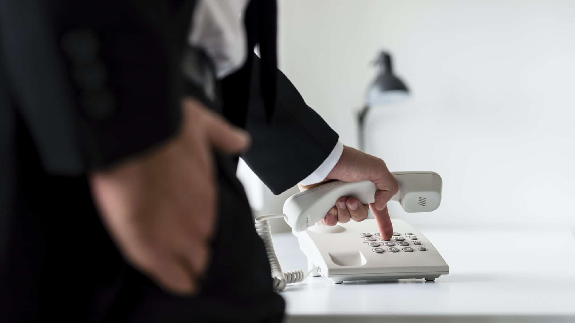 Rear view of a businessman dialing telephone number